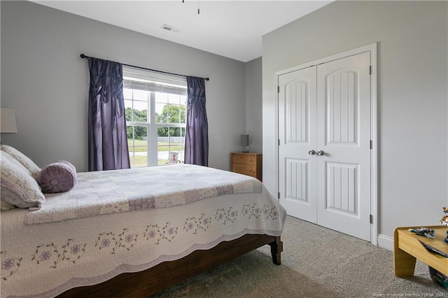 carpeted bedroom featuring visible vents and a closet