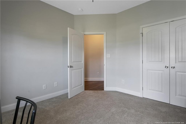 unfurnished bedroom with a closet, carpet flooring, and baseboards