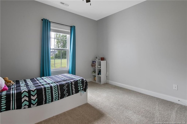 carpeted bedroom featuring visible vents, baseboards, and a ceiling fan