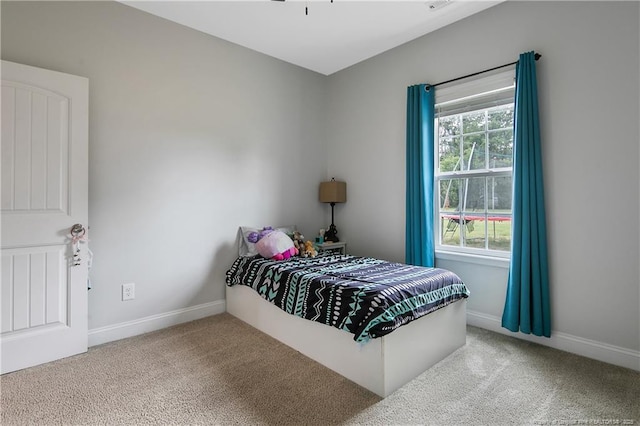 bedroom with multiple windows, baseboards, and carpet