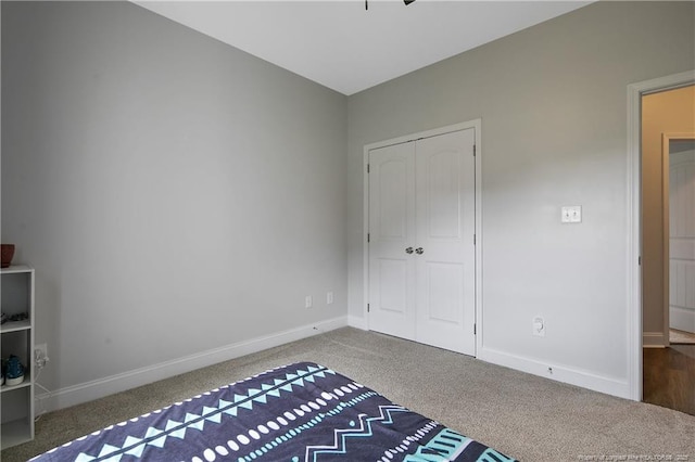 unfurnished bedroom featuring a closet, baseboards, and carpet floors