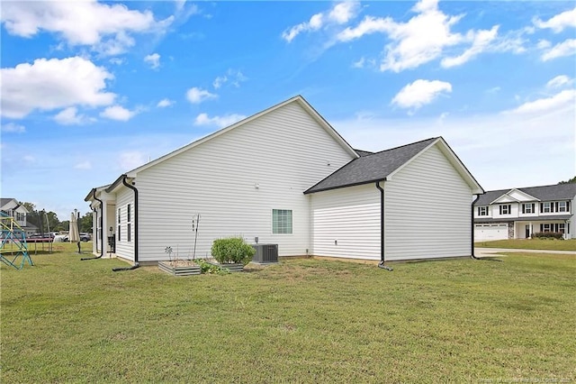 back of property with a yard, a trampoline, central AC, and a garage