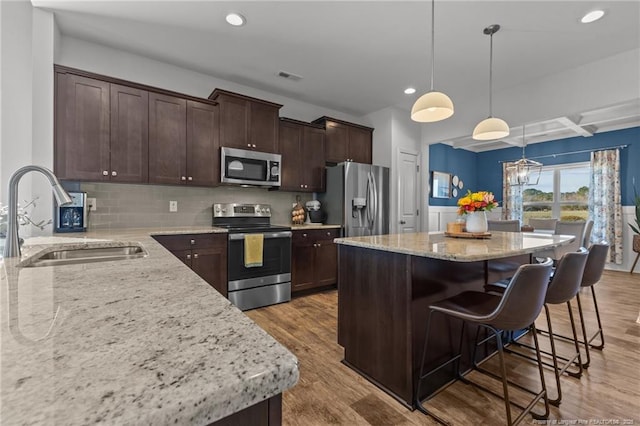 kitchen featuring a sink, light wood-type flooring, appliances with stainless steel finishes, and dark brown cabinets