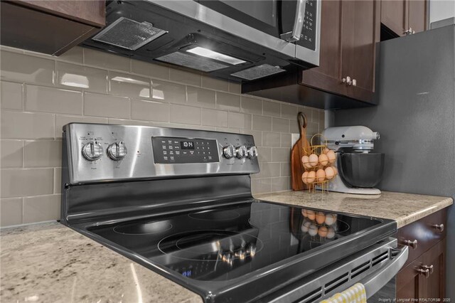 kitchen featuring tasteful backsplash, dark brown cabinetry, and appliances with stainless steel finishes