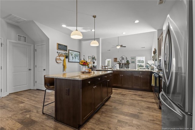 kitchen featuring visible vents, dark brown cabinets, black range with electric stovetop, dark wood-type flooring, and freestanding refrigerator