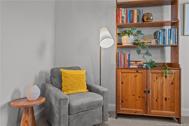 living area with baseboards and carpet