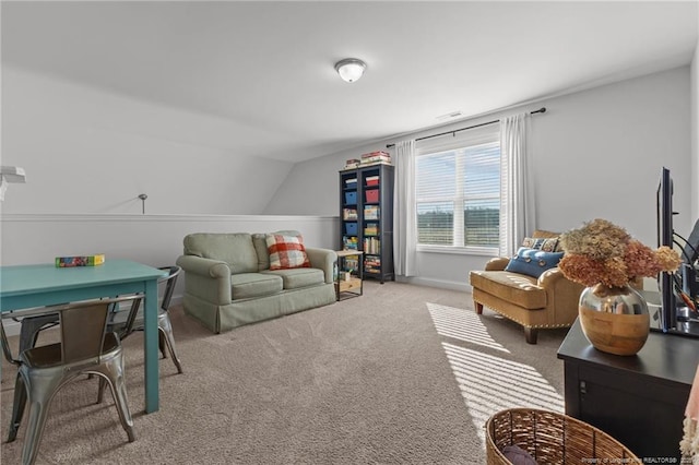 carpeted living area with visible vents, baseboards, and lofted ceiling