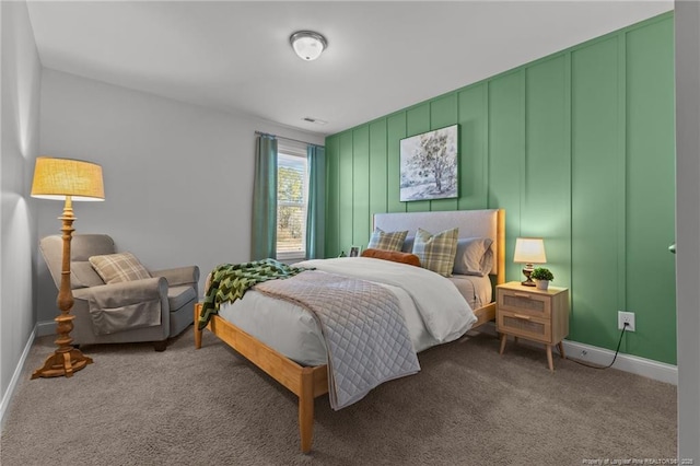 carpeted bedroom with a decorative wall and baseboards