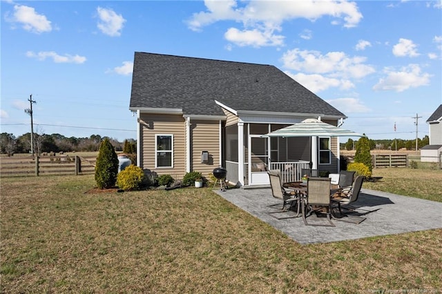 rear view of house featuring a lawn, fence, a patio, and a sunroom