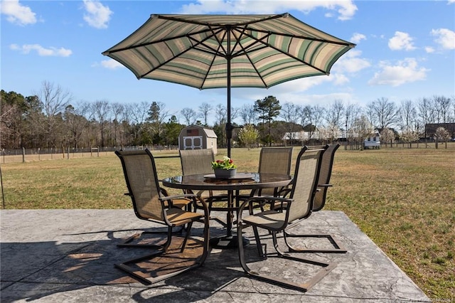 view of patio with outdoor dining space, a storage shed, and an outdoor structure