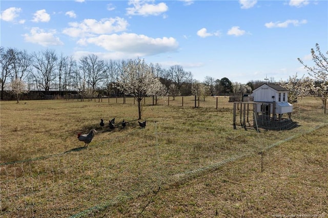 view of yard with an outbuilding, a rural view, and exterior structure