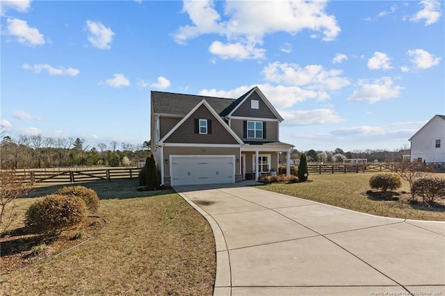 craftsman-style home featuring a garage, concrete driveway, a front lawn, and fence