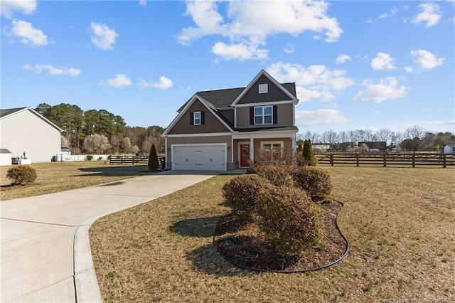 craftsman-style house with an attached garage, concrete driveway, a front yard, and fence