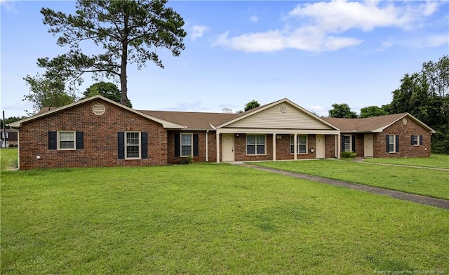 ranch-style house featuring a front lawn and brick siding