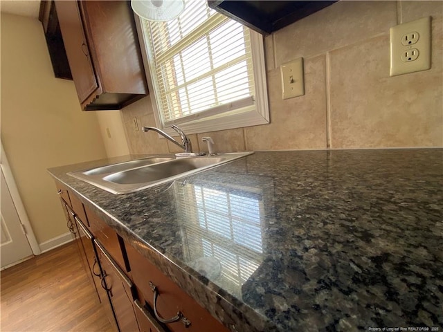 kitchen featuring brown cabinets, light wood-style floors, and a sink