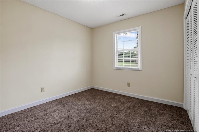 unfurnished bedroom with a closet, visible vents, baseboards, and carpet floors