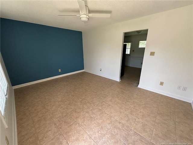 unfurnished room with baseboards, a textured ceiling, and a ceiling fan