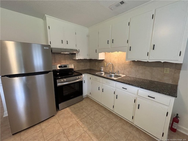 kitchen featuring dark countertops, visible vents, under cabinet range hood, stainless steel appliances, and a sink