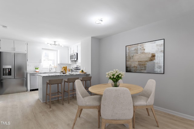 dining room with baseboards and light wood-style floors