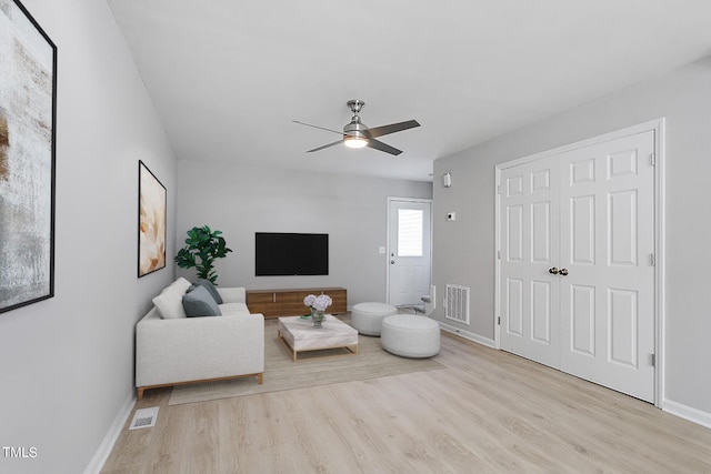 living room featuring baseboards, wood finished floors, visible vents, and ceiling fan