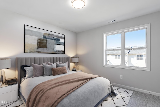 bedroom with light carpet, visible vents, and baseboards