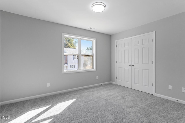 unfurnished bedroom featuring a closet, baseboards, visible vents, and carpet floors