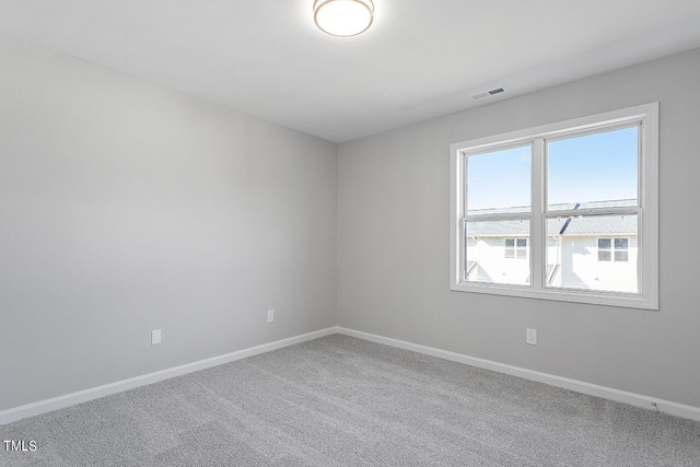 empty room featuring carpet flooring, baseboards, and visible vents