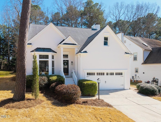 modern farmhouse with stucco siding, driveway, a chimney, and a garage