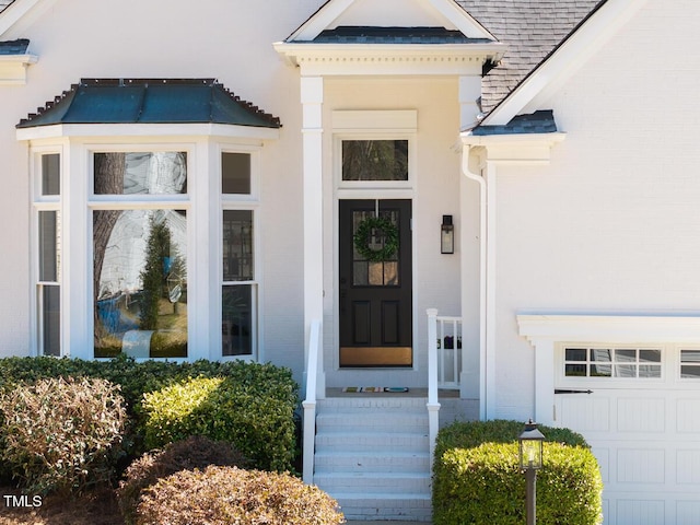 doorway to property featuring brick siding and a garage