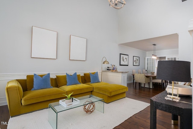 living room featuring a high ceiling, wood finished floors, and ornamental molding