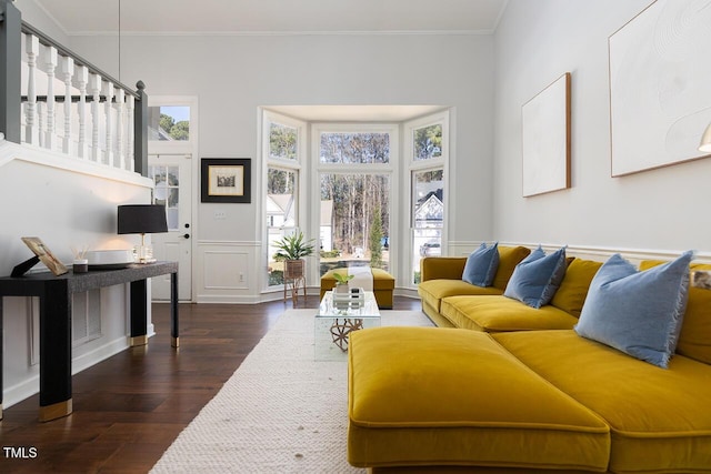 living area featuring dark wood-type flooring, plenty of natural light, and crown molding