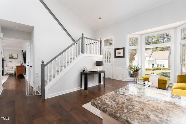 foyer featuring stairs, crown molding, a towering ceiling, and hardwood / wood-style floors