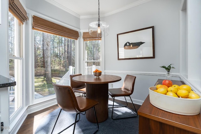 dining room featuring crown molding, wood finished floors, and baseboards