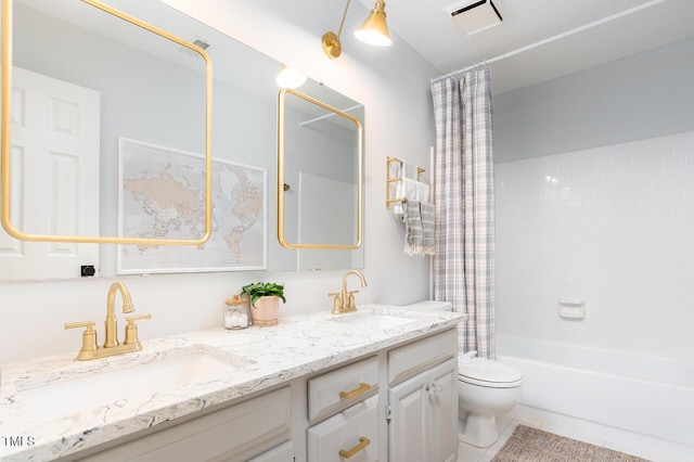 bathroom with a sink, toilet, double vanity, and tile patterned floors