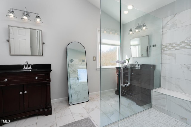 bathroom featuring lofted ceiling, marble finish floor, tiled shower, baseboards, and vanity