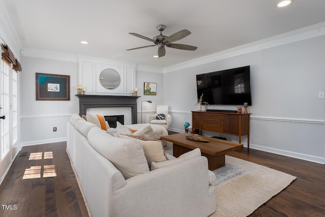 living room with ceiling fan, wood finished floors, a fireplace, and crown molding