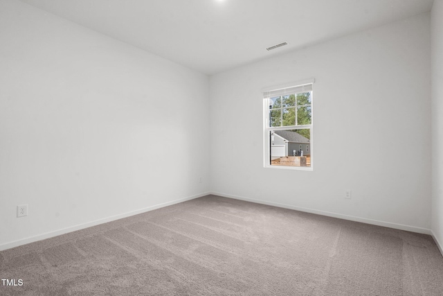 spare room with baseboards, visible vents, and carpet floors