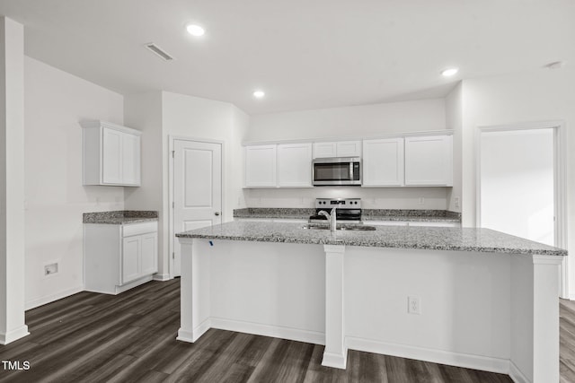 kitchen with a sink, stainless steel appliances, light stone counters, and visible vents