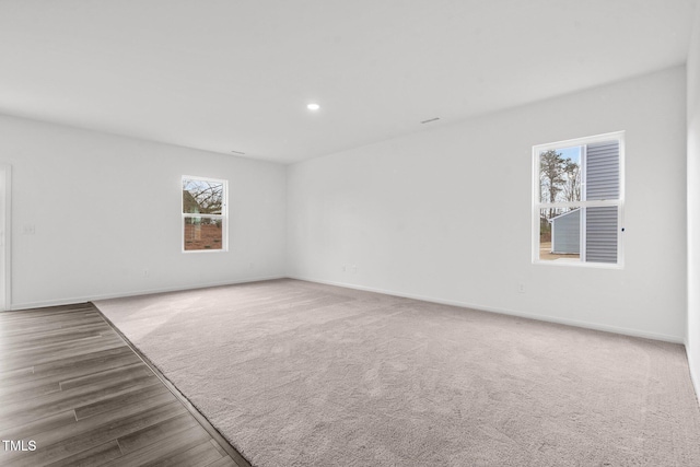 carpeted empty room featuring recessed lighting and baseboards