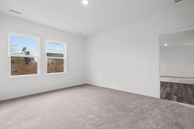 spare room featuring recessed lighting, visible vents, baseboards, and carpet