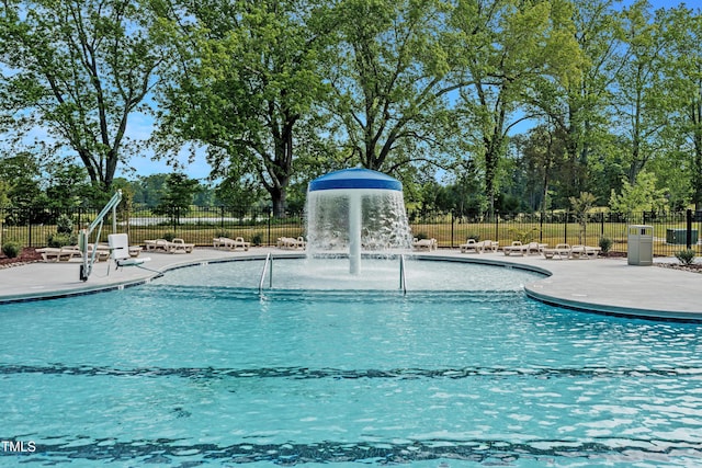 community pool with a patio area and fence