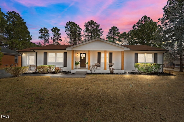 single story home with brick siding, covered porch, and a front lawn