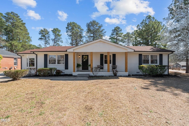 ranch-style home with brick siding, covered porch, and a front lawn