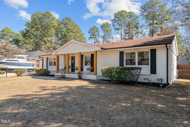 single story home featuring brick siding, crawl space, covered porch, and fence