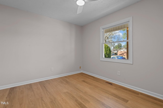 unfurnished room with visible vents, baseboards, light wood-style flooring, and a ceiling fan