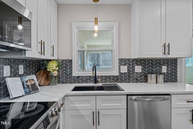 kitchen featuring a sink, decorative backsplash, appliances with stainless steel finishes, and white cabinetry