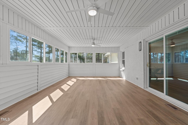 unfurnished sunroom featuring a wealth of natural light, visible vents, and a ceiling fan