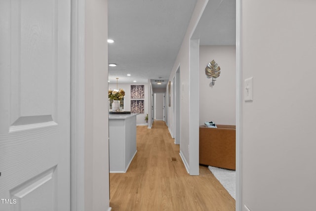 hall featuring visible vents, recessed lighting, light wood-type flooring, and baseboards