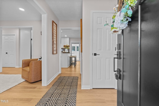 foyer featuring recessed lighting, baseboards, and light wood-style flooring