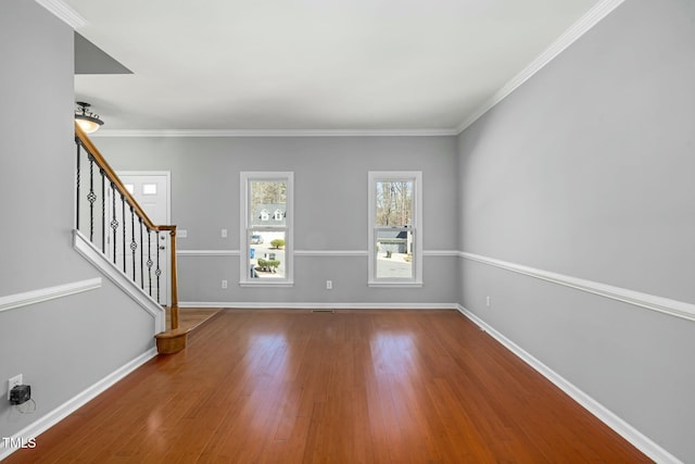 interior space featuring stairs, crown molding, wood finished floors, and baseboards